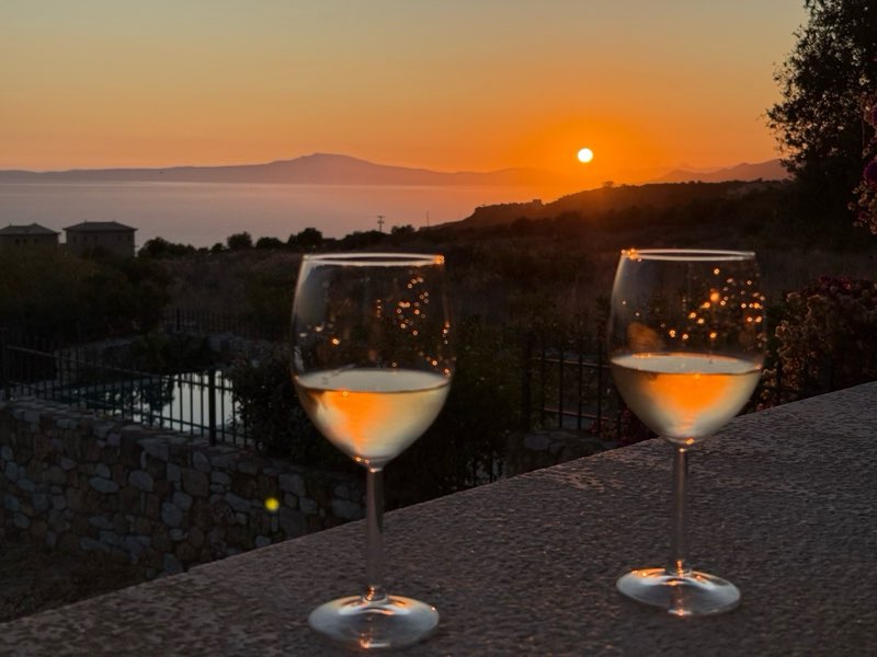 Two wine glasses at sunset over the sea